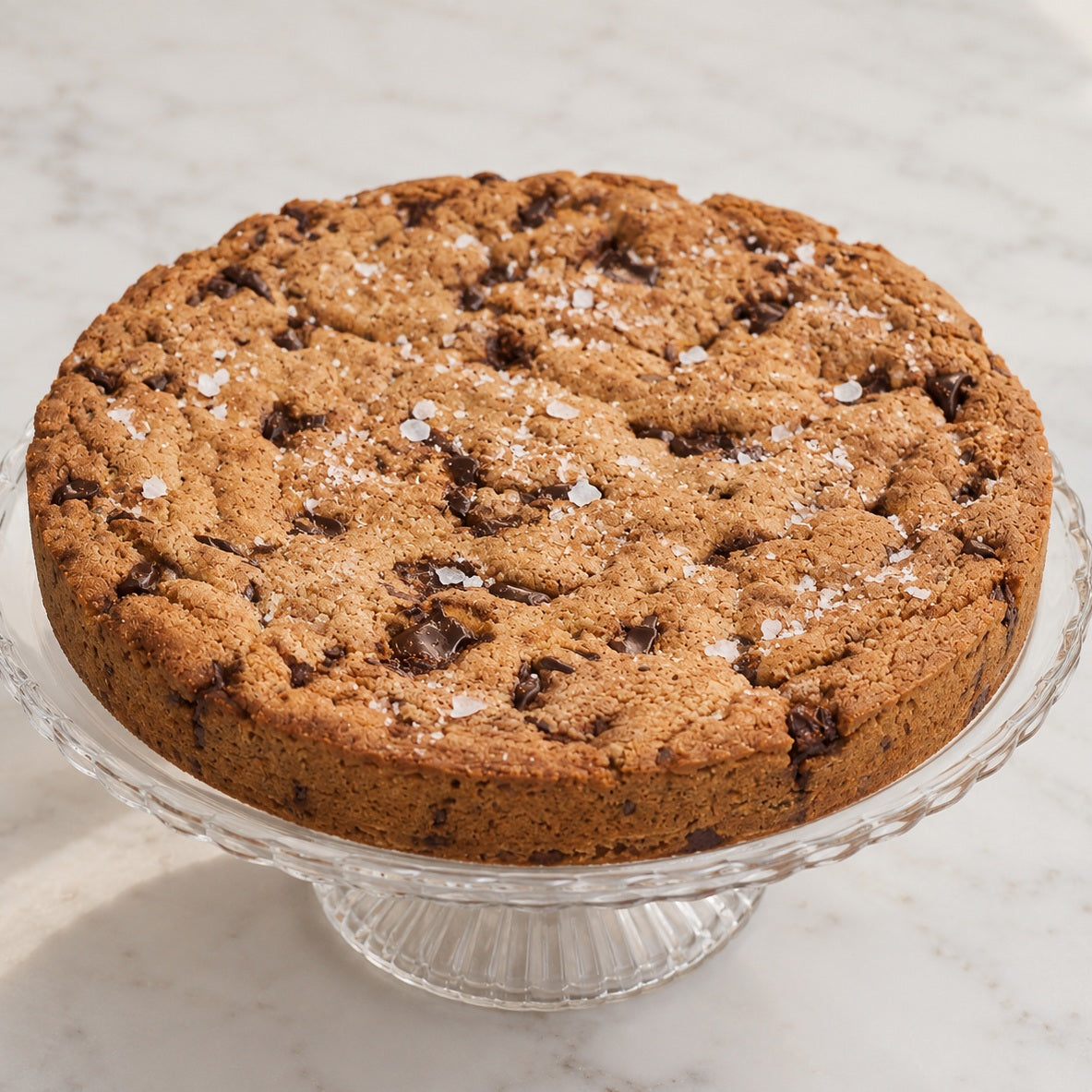 Chocolate olive oil cookie cake square view on glass cake stand